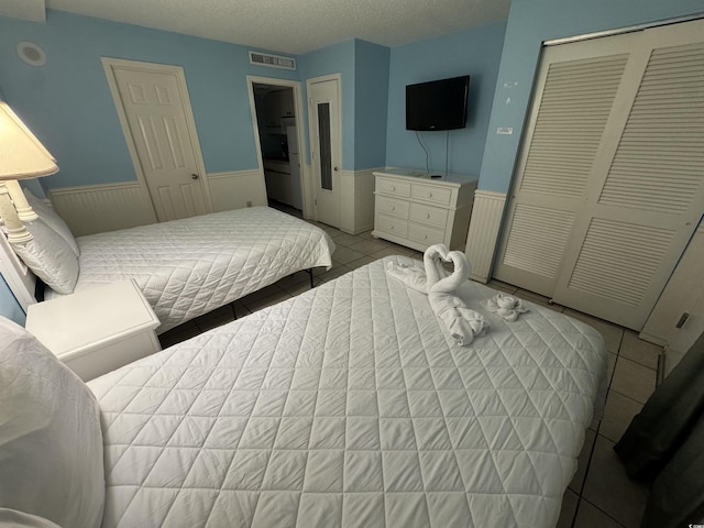 7500 N Ocean Blvd Unit 6120, Myrtle Beach, SC 29572 - bedroom featuring wainscoting, a closet, and light tile patterned flooring