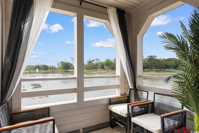 sunroom / solarium with a water view and healthy amount of natural light
