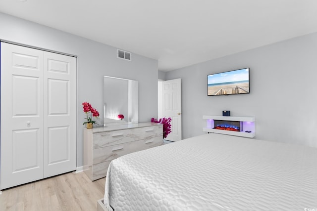 bedroom with light wood-style flooring and a closet