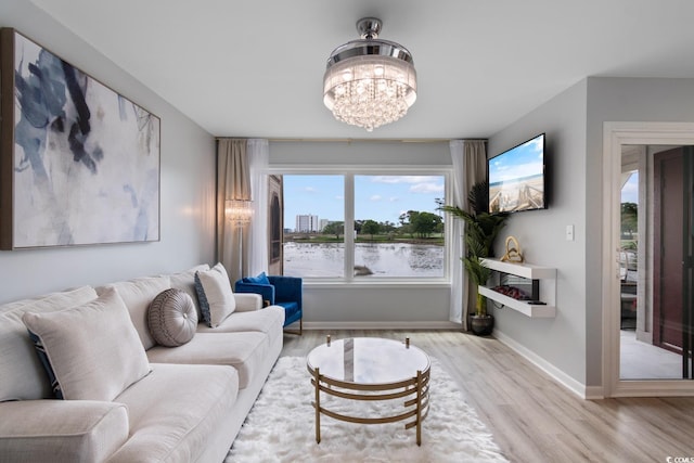 living area featuring wood finished floors, a chandelier, and baseboards