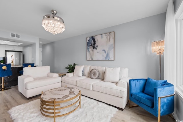 living area featuring a chandelier and light wood-style flooring