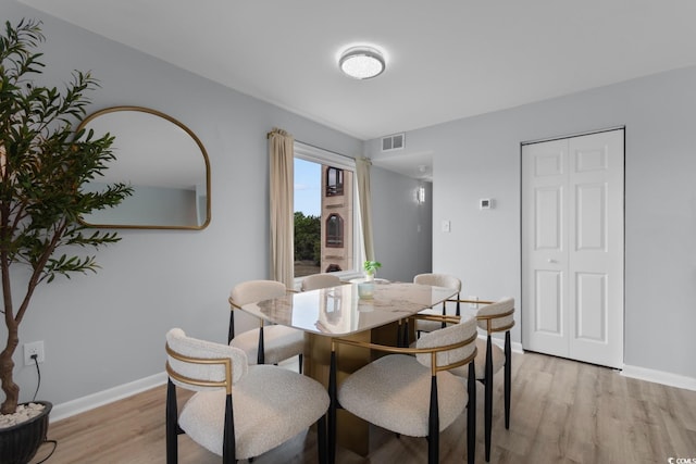 dining room featuring light wood-type flooring and baseboards