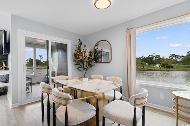 dining area with light wood-type flooring and baseboards