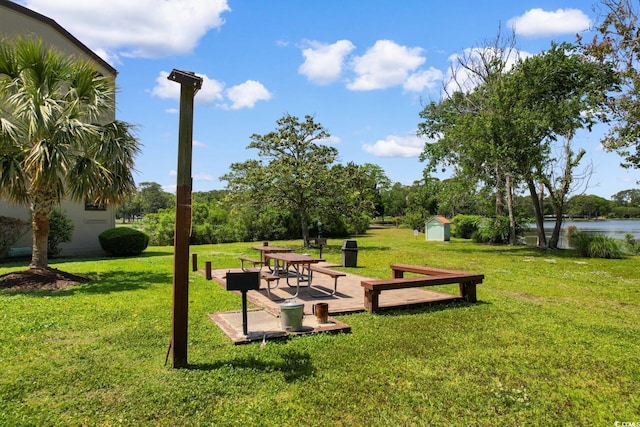 surrounding community featuring a shed, a lawn, an outbuilding, and a water view