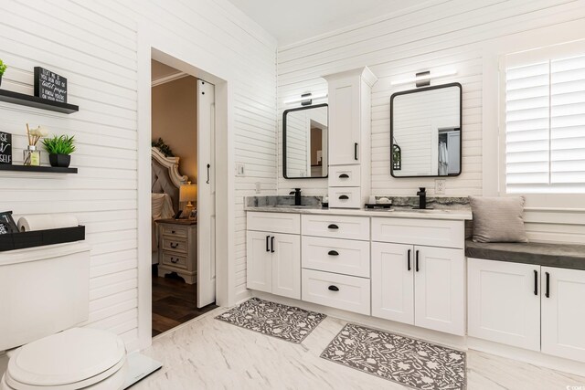 3757 Kingsley Dr, Myrtle Beach, SC 29588 - full bathroom with wood walls, double vanity, toilet, and marble look tiles
