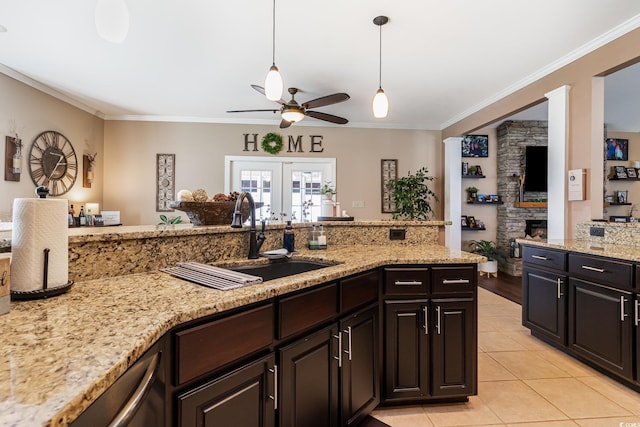 3757 Kingsley Dr, Myrtle Beach, SC 29588 - kitchen with a sink, a ceiling fan, ornamental molding, a fireplace, and light stone counters