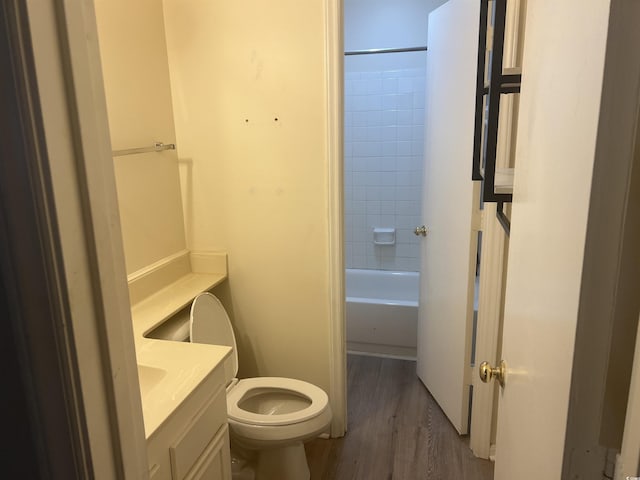 full bathroom with wood finished floors, vanity, toilet, and washtub / shower combination