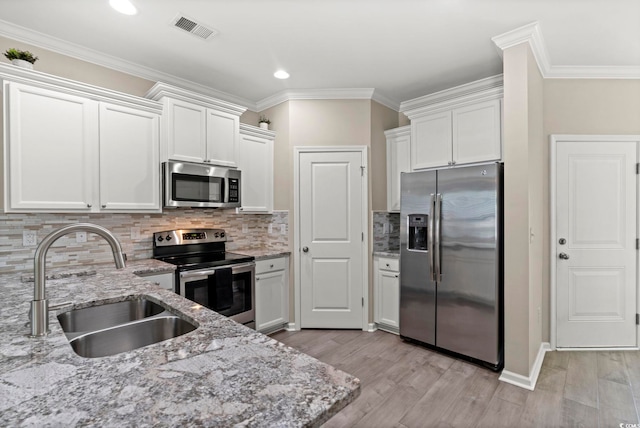 448 Papyrus Cir Unit 448, Little River, SC 29566 - kitchen with stainless steel appliances, a sink, light wood-style floors, white cabinets, and crown molding