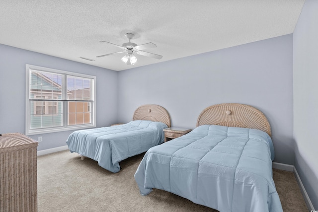 carpeted bedroom featuring baseboards, a ceiling fan, and a textured ceiling