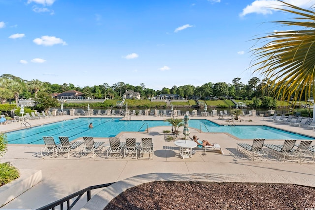 community pool featuring fence and a patio