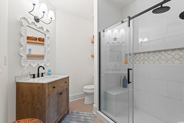 bathroom with a shower stall, toilet, vanity, and tile patterned floors