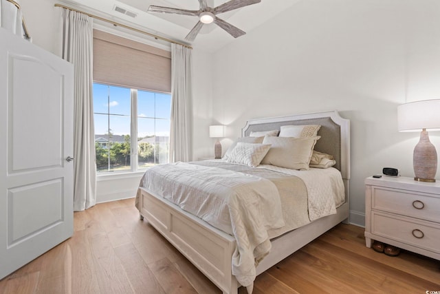 bedroom featuring light wood-style flooring, a ceiling fan, and lofted ceiling