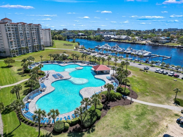 drone / aerial view of a pool and a nearby body of water