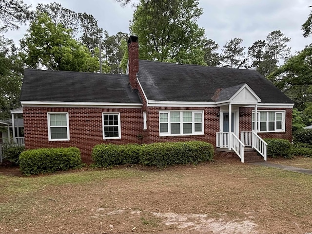 307 Pressley Ave, Kingstree, SC 29556 - view of front facade with brick siding, a chimney, and a front yard