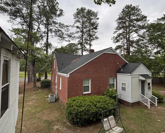 307 Pressley Ave, Kingstree, SC 29556 - view of home's exterior featuring brick siding, a shingled roof, entry steps, and a chimney