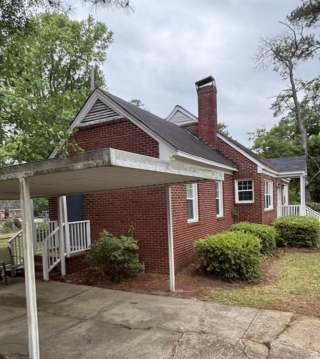 307 Pressley Ave, Kingstree, SC 29556 - view of property exterior featuring brick siding, a chimney, and a carport
