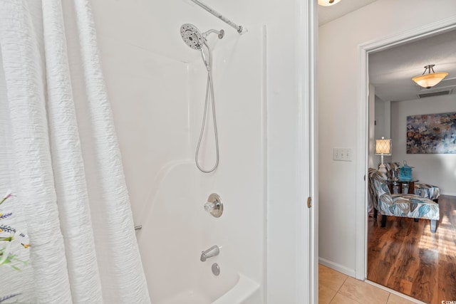bathroom featuring tile patterned floors, shower / bath combination with curtain, connected bathroom, and baseboards
