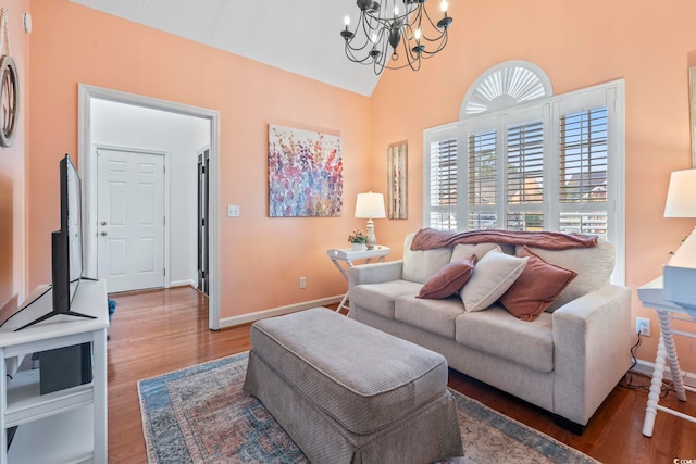 living room featuring a chandelier, wood finished floors, baseboards, and high vaulted ceiling