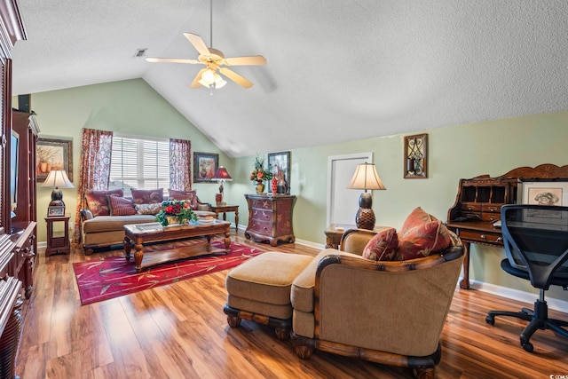 living room with a ceiling fan, lofted ceiling, wood finished floors, a textured ceiling, and baseboards
