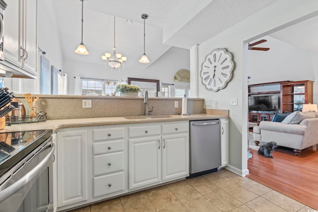 kitchen featuring stainless steel appliances, vaulted ceiling, a sink, decorative backsplash, and light countertops