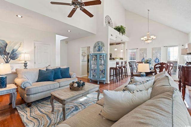living room with wood finished floors, a chandelier, ceiling fan, high vaulted ceiling, and recessed lighting