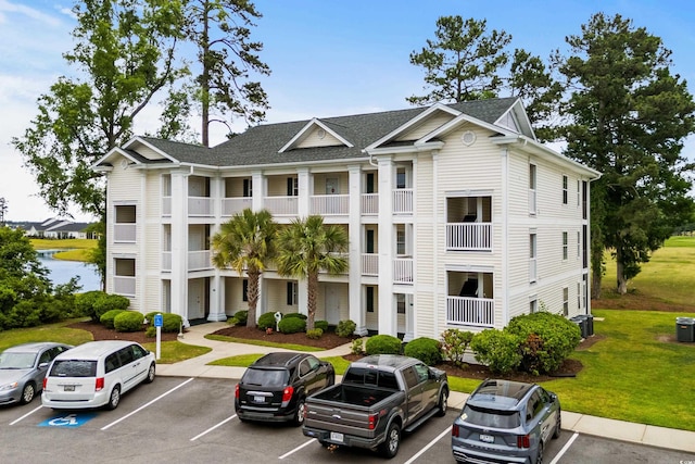view of property with uncovered parking and central AC unit