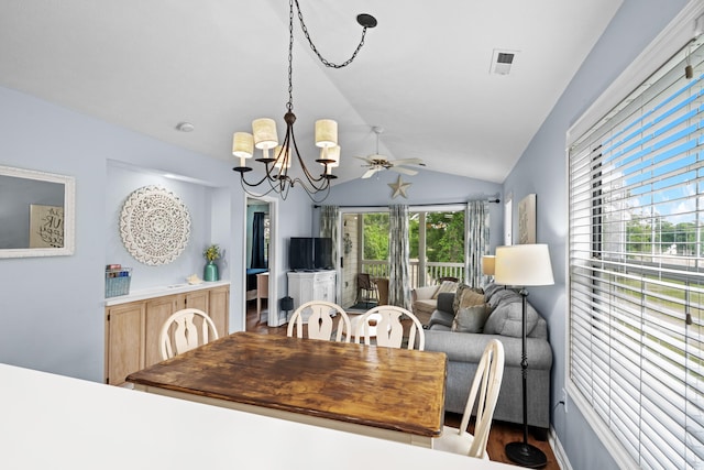 dining space with lofted ceiling, a chandelier, and a ceiling fan