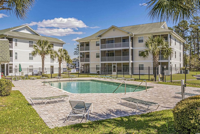 community pool with fence and a patio area