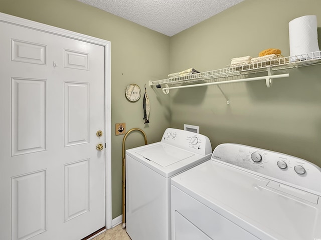 laundry room with washer and dryer and a textured ceiling