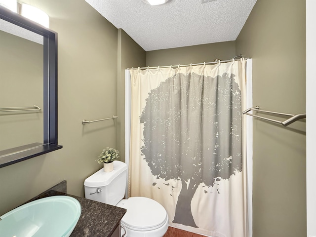 bathroom with a textured ceiling, toilet, vanity, and a shower with shower curtain