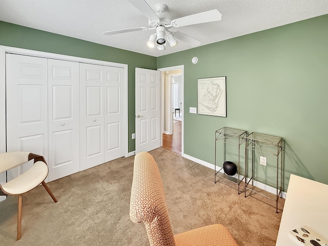 interior space featuring carpet floors, ceiling fan, baseboards, and a textured ceiling