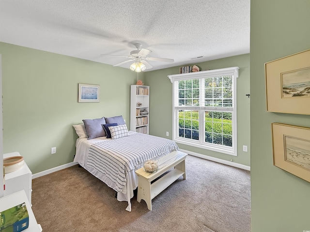 bedroom featuring carpet, baseboards, a textured ceiling, and ceiling fan
