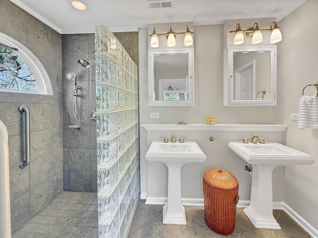 full bathroom with a walk in shower, tile patterned floors, baseboards, and a sink