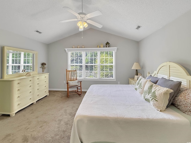 bedroom with light carpet, lofted ceiling, a textured ceiling, baseboards, and a ceiling fan