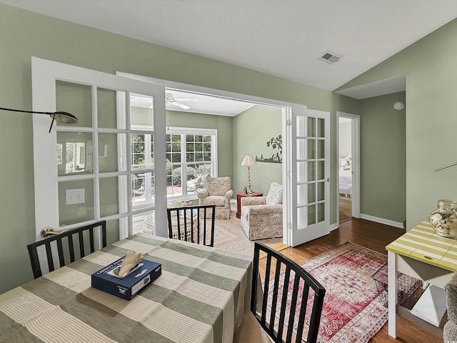 dining room featuring ceiling fan, wood finished floors, lofted ceiling, and baseboards