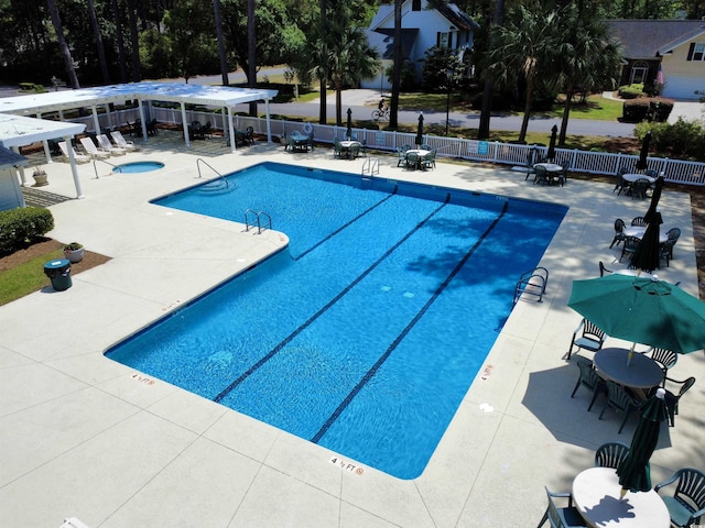 community pool with fence, a hot tub, a patio area, and a pergola