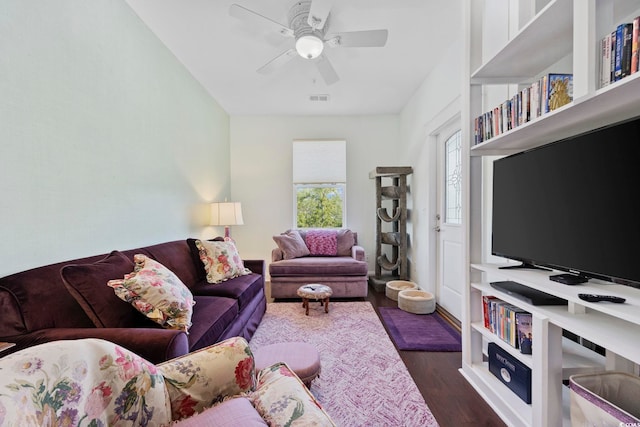 living area with dark wood-type flooring and a ceiling fan