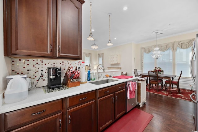 kitchen with a sink, dishwasher, light countertops, tasteful backsplash, and a chandelier