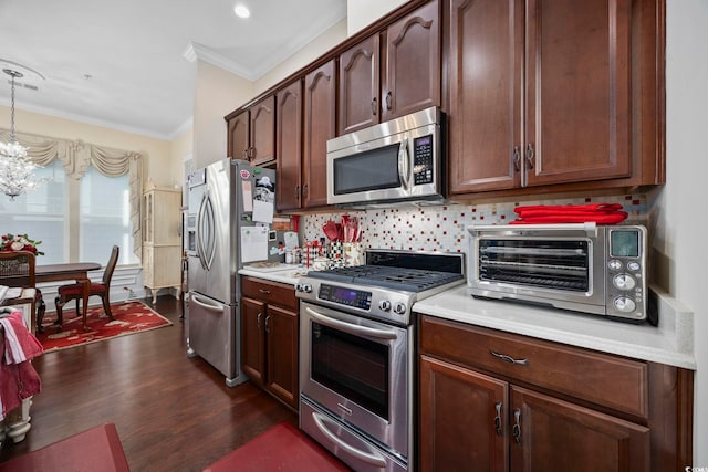 kitchen with stainless steel appliances, light countertops, a chandelier, dark wood-style floors, and crown molding