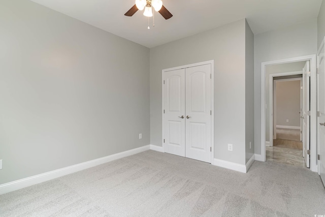 unfurnished bedroom with carpet floors, a closet, baseboards, and ceiling fan