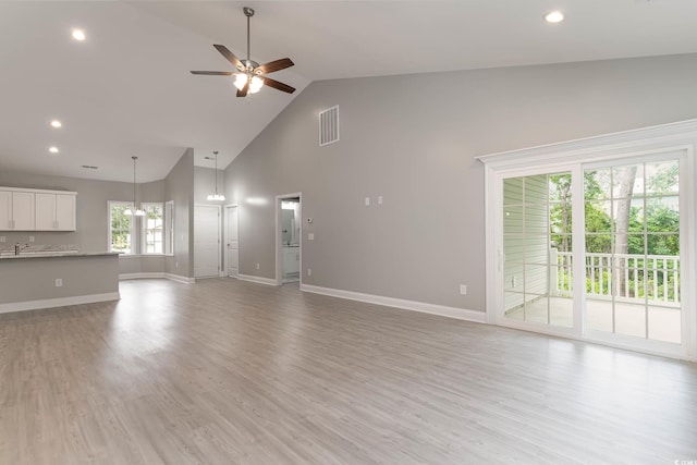 unfurnished living room with ceiling fan, high vaulted ceiling, baseboards, light wood-style floors, and recessed lighting
