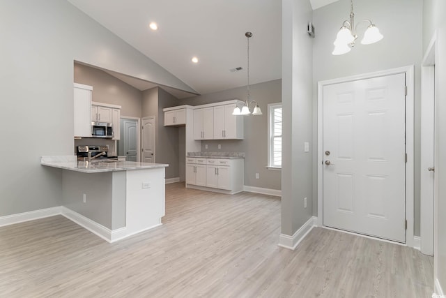 kitchen featuring stainless steel appliances, a chandelier, white cabinetry, high vaulted ceiling, and light wood-style flooring