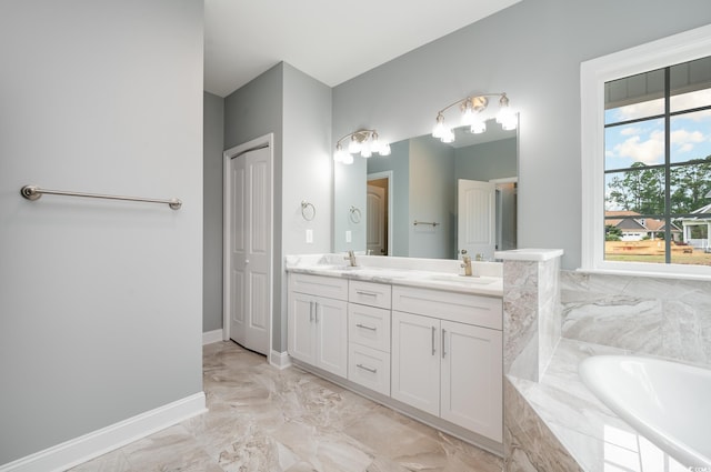 bathroom featuring double vanity, marble finish floors, baseboards, and a garden tub