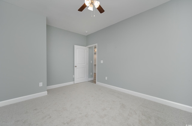 unfurnished room featuring a ceiling fan, carpet, and baseboards
