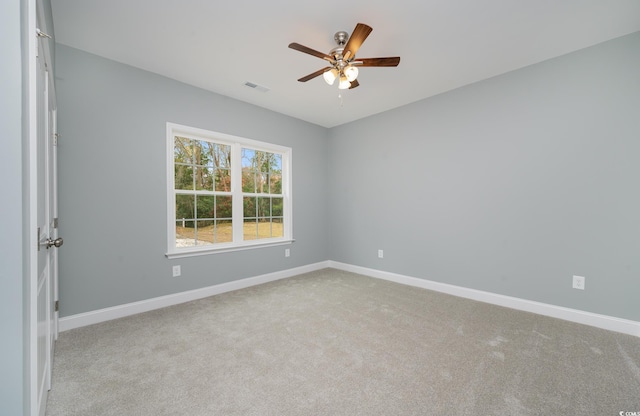 carpeted empty room featuring ceiling fan and baseboards