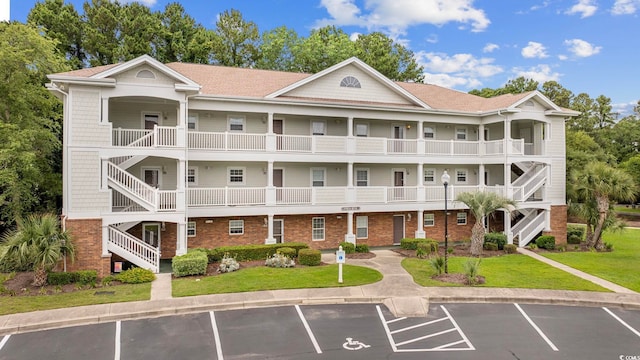 view of building exterior with stairway and uncovered parking