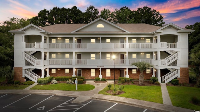 property at dusk featuring stairway and uncovered parking
