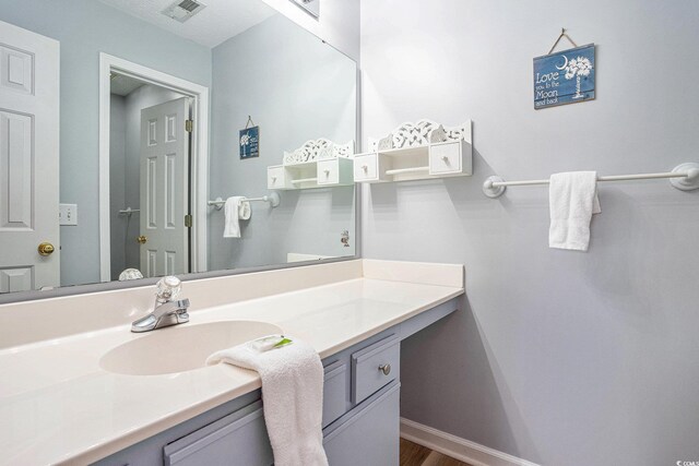 bathroom with vanity, baseboards, and wood finished floors