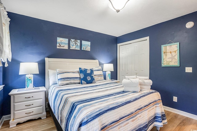 bedroom featuring wood finished floors, a closet, and baseboards