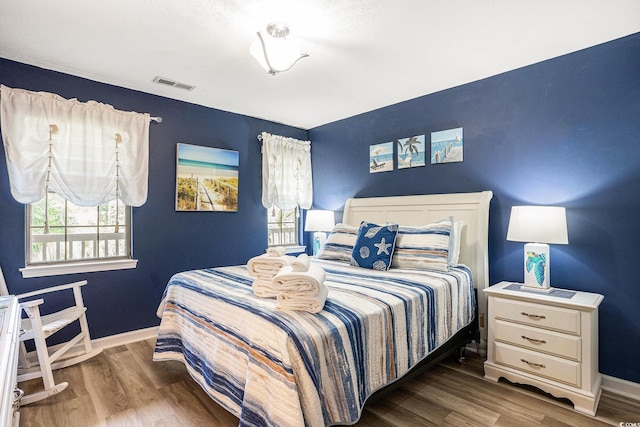 bedroom with wood finished floors and baseboards